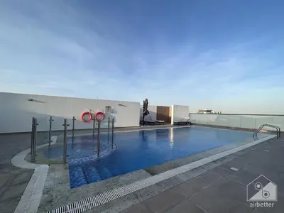 a swimming pool on the roof of a building at NEW! Amazing Studio in Al Majan in Dubai