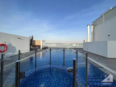 a swimming pool on the roof of a building at NEW! Amazing Studio in Al Majan in Dubai