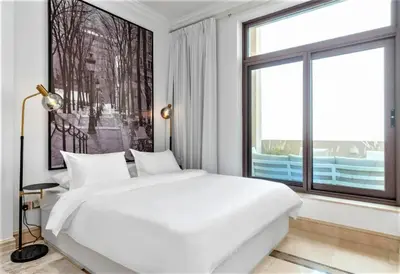 a white bedroom with a large bed and a large window at NEW! Exclusive Fairmont Penthouse private Pool-Gym in Dubai