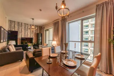 a living room with a table and a large window at Bellavista - Ultra Modern - 2BR - Boulevard Central - Burj Khalifa View in Dubai