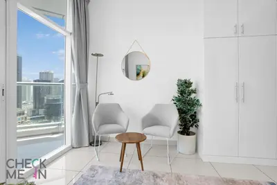 a white living room with two chairs and a table at Luxury 2BR with Breath-taking Dubai Marina Views in Dubai