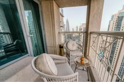 a balcony with two chairs and a table at Bellavista - Spacious - 1BR with Extra Room - 29 Boulevard - Partial Fountain View in Dubai