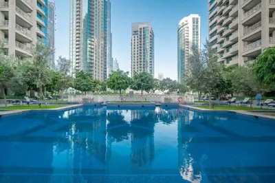 a large swimming pool in a city with tall buildings at Bellavista - Spacious - 1BR with Extra Room - 29 Boulevard - Partial Fountain View in Dubai