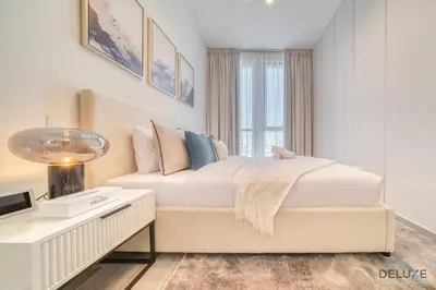 a white bedroom with a bed and a table at Exquisite 2BR with Assistant Room at Mesk 1 Midtown Dubai Production City by Deluxe Holiday Homes in Dubai