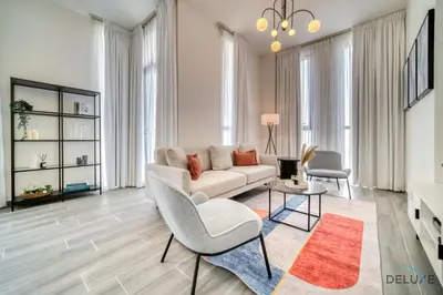 a living room with a couch and a table at Impressive 2BR with Assistant Room at Mesk 1 Midtown Dubai Production City by Deluxe Holiday Homes in Dubai