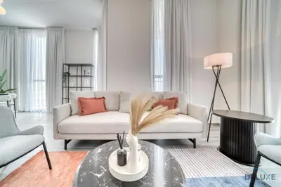 a living room with a couch and a table at Impressive 2BR with Assistant Room at Mesk 1 Midtown Dubai Production City by Deluxe Holiday Homes in Dubai