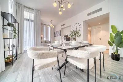 a dining room with a table and chairs at Impressive 2BR with Assistant Room at Mesk 1 Midtown Dubai Production City by Deluxe Holiday Homes in Dubai