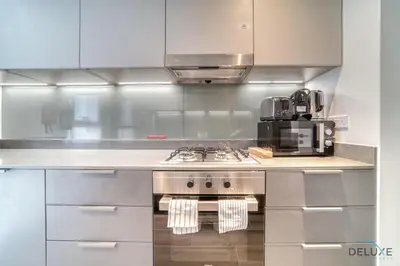 a kitchen with a stove and a microwave at Impressive 2BR with Assistant Room at Mesk 1 Midtown Dubai Production City by Deluxe Holiday Homes in Dubai