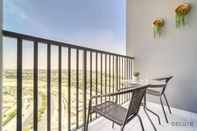 a balcony with a table and chairs and a view at Impressive 2BR with Assistant Room at Mesk 1 Midtown Dubai Production City by Deluxe Holiday Homes in Dubai