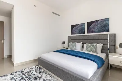 a bedroom with a large bed with a blue blanket at Frank Porter - 17 Icon Bay in Dubai