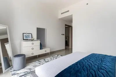 a bedroom with a bed and a dresser and a mirror at Frank Porter - 17 Icon Bay in Dubai
