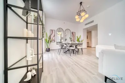 a living room with a table and chairs and a couch at Harmonious 2BR with Assistant Room at Mesk 1 Midtown Dubai Production City by Deluxe Holiday Homes in Dubai