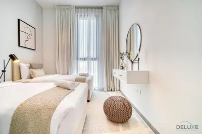 a white bedroom with a large bed and a mirror at Harmonious 2BR with Assistant Room at Mesk 1 Midtown Dubai Production City by Deluxe Holiday Homes in Dubai