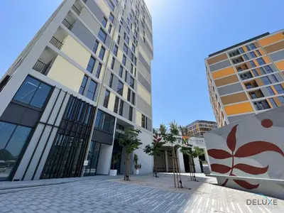 a building in a city with two tall buildings at Harmonious 2BR with Assistant Room at Mesk 1 Midtown Dubai Production City by Deluxe Holiday Homes in Dubai