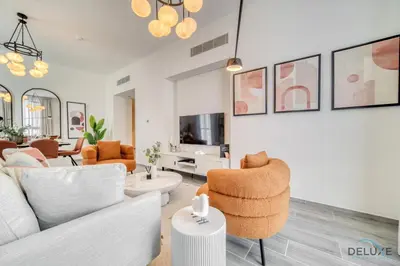 a living room with a couch and chairs and a tv at Idyllic 2BR with Assistant Room at Mesk 1 Midtown Dubai Production City by Deluxe Holiday Homes in Dubai