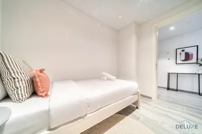 a white couch in a room with a table at Idyllic 2BR with Assistant Room at Mesk 1 Midtown Dubai Production City by Deluxe Holiday Homes in Dubai