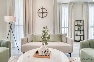 a living room with a couch and a table at Suave 2BR with Assistant Room at Mesk 1 Midtown Dubai Production City by Deluxe Holiday Homes in Dubai