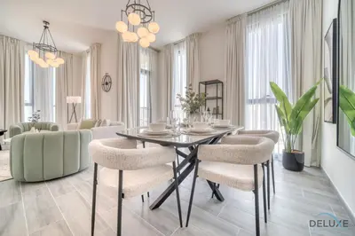 a dining room with a table and chairs at Suave 2BR with Assistant Room at Mesk 1 Midtown Dubai Production City by Deluxe Holiday Homes in Dubai