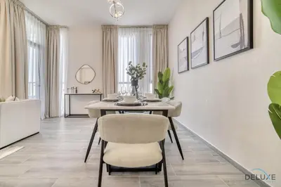 a dining room with a table and chairs at Refined 2BR with Assistant Room at Mesk 1 Midtown Dubai Production City by Deluxe Holiday Homes in Dubai