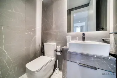 a bathroom with a white toilet and a sink at Refined 2BR with Assistant Room at Mesk 1 Midtown Dubai Production City by Deluxe Holiday Homes in Dubai