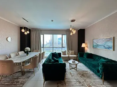 a living room with a green couch and a table at Durrani Homes - Grand 5BR besides Burj khalifa and Fountain view in Dubai