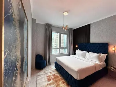 a bedroom with a bed and a large window at Durrani Homes - Grand 5BR besides Burj khalifa and Fountain view in Dubai