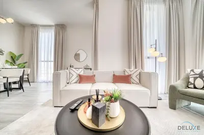 a living room with a white couch and a table at Pleasant 2BR with Assistant Room at Mesk 1 Midtown Dubai Production City by Deluxe Holiday Homes in Dubai