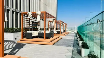 a row of tables and chairs on the side of a building at The Shrashi Suites, Dubai Creek Harbour - Paradise on the Island with Dubai Skyline & Waterfront View in Dubai