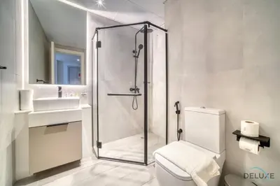 a bathroom with a shower and a toilet and a sink at Striking Studio at Mesk 1 Midtown Dubai Production City by Deluxe Holiday Homes in Dubai
