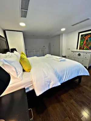 a bedroom with a large white bed with yellow pillows at Stunning Duplex Studio in JLT in Dubai