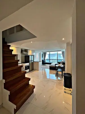 a living room and kitchen with a staircase in a house at Stunning Duplex Studio in JLT in Dubai