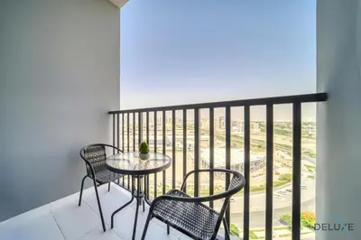 a table and chairs on a balcony with a view at Splendid Studio at Mesk 1 Midtown Dubai Production City by Deluxe Holiday Homes in Dubai