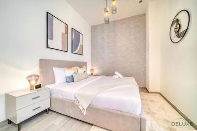 a bedroom with a large white bed and a mirror at Splendid Studio at Mesk 1 Midtown Dubai Production City by Deluxe Holiday Homes in Dubai