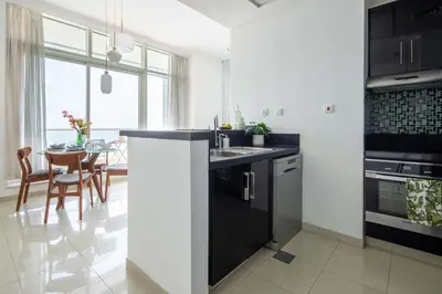 a kitchen with black and white appliances and a table at Frank Porter - Botanica Tower 1 in Dubai