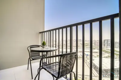 a balcony with a table and chairs and a view of the city at Enchanting Studio at Mesk 1 Midtown Dubai Production City by Deluxe Holiday Homes in Dubai