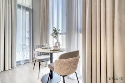 a dining room with a table and chairs and a window at Upscale Studio at Mesk 1 Midtown Dubai Production City by Deluxe Holiday Homes in Dubai