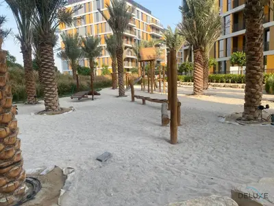 a playground with palm trees in front of a building at Upscale Studio at Mesk 1 Midtown Dubai Production City by Deluxe Holiday Homes in Dubai