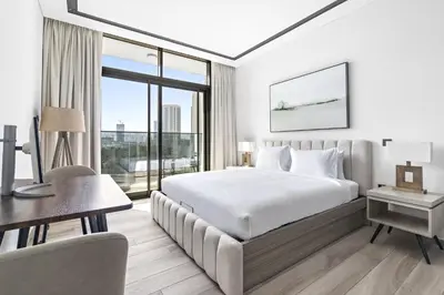 a hotel room with a bed and a desk and a desk at ALiving Luxury Studio I Nicholas Residence, JVC in Dubai