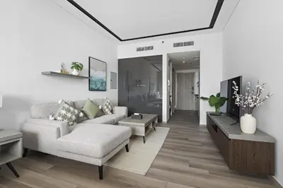 a living room with a couch and a table at ALiving Luxury Studio I Nicholas Residence, JVC in Dubai
