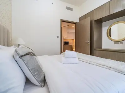 a bedroom with a large white bed with a mirror at Radiant 1BR in Burj Royale - Downtown Dubai in Dubai