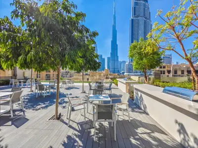 a patio with tables and chairs with a view of the city at Pleasant 1BR in Burj Royale - Downtown Dubai in Dubai