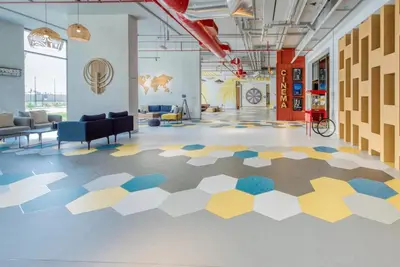 a lobby with a hexagonal floor in a building at Sleek Studio at UNA Town Square Dubailand by Deluxe Holiday Homes in Dubai