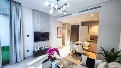 a living room with a table and a dining room at STAY BY LATINEM Luxury 1BR Holiday Home CV A103 near Burj Khalifa in Dubai