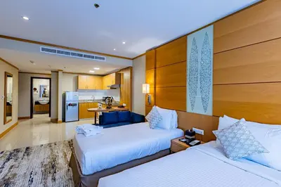 a hotel room with two beds and a kitchen at Carlton Downtown Hotel in Dubai