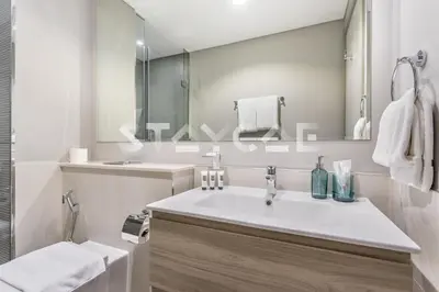 a white bathroom with a sink and a mirror at Staycae Holiday Homes - ZADA in Dubai