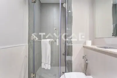 a bathroom with a shower with a toilet and a sink at Staycae Holiday Homes - ZADA in Dubai