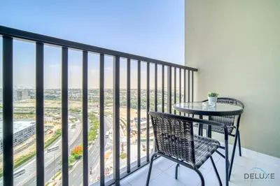 a balcony with a table and chair and a view at Polished Studio at Mesk 1 Midtown Dubai Production City by Deluxe Holiday Homes in Dubai