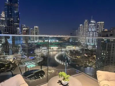 a view of a city at night from a balcony at Opera Grand by Luxstay Holiday Homes in Dubai