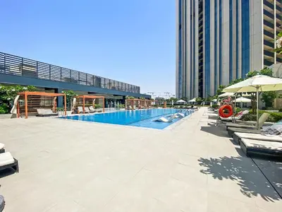 a large swimming pool in a city with a building at Silkhaus brand new 1BDR in Creek Harbour in Dubai