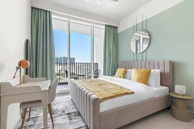 a bedroom with a bed and a desk and a window at Silkhaus brand new 1BDR in Creek Harbour in Dubai